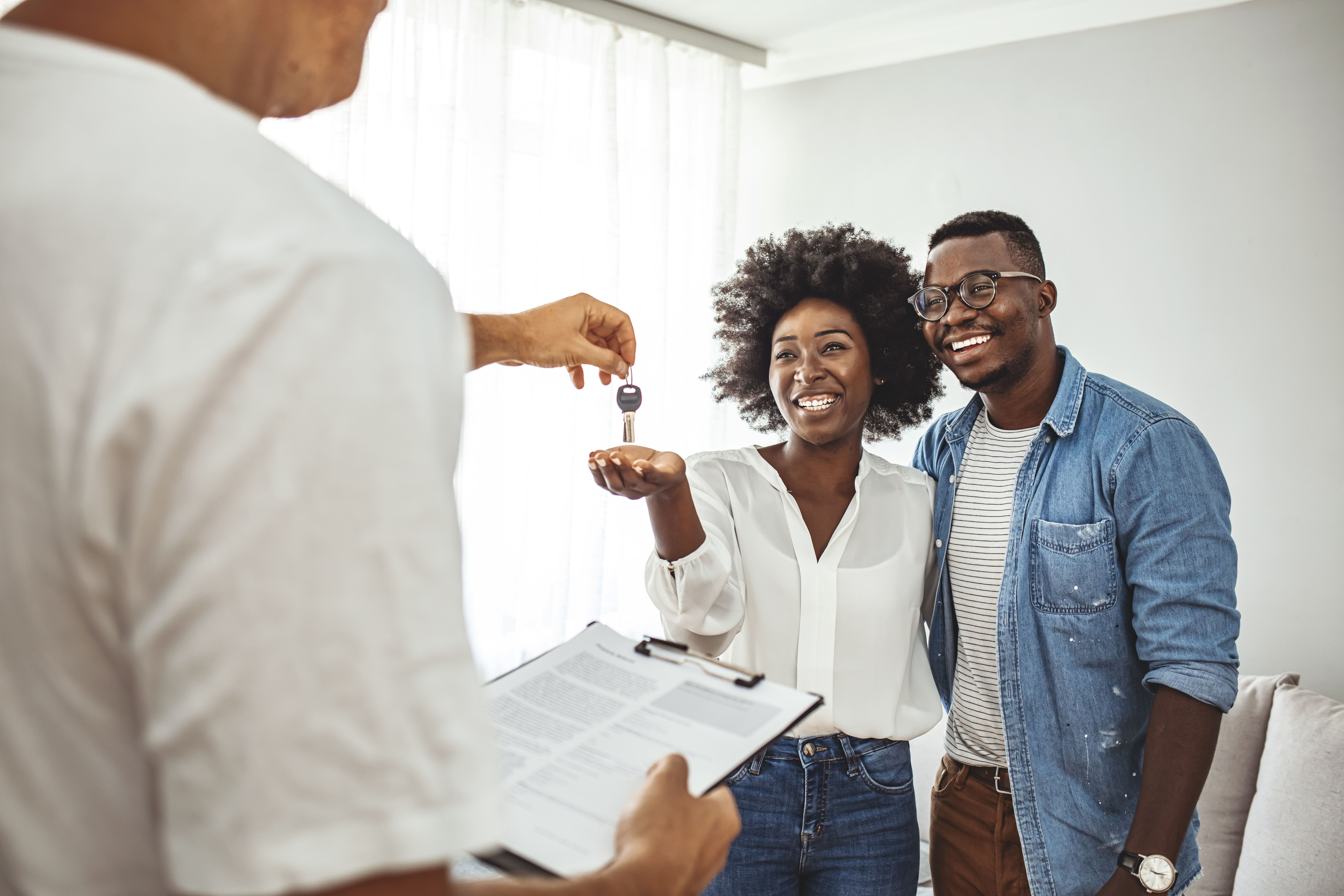 Realtor handing house keys to homeowners