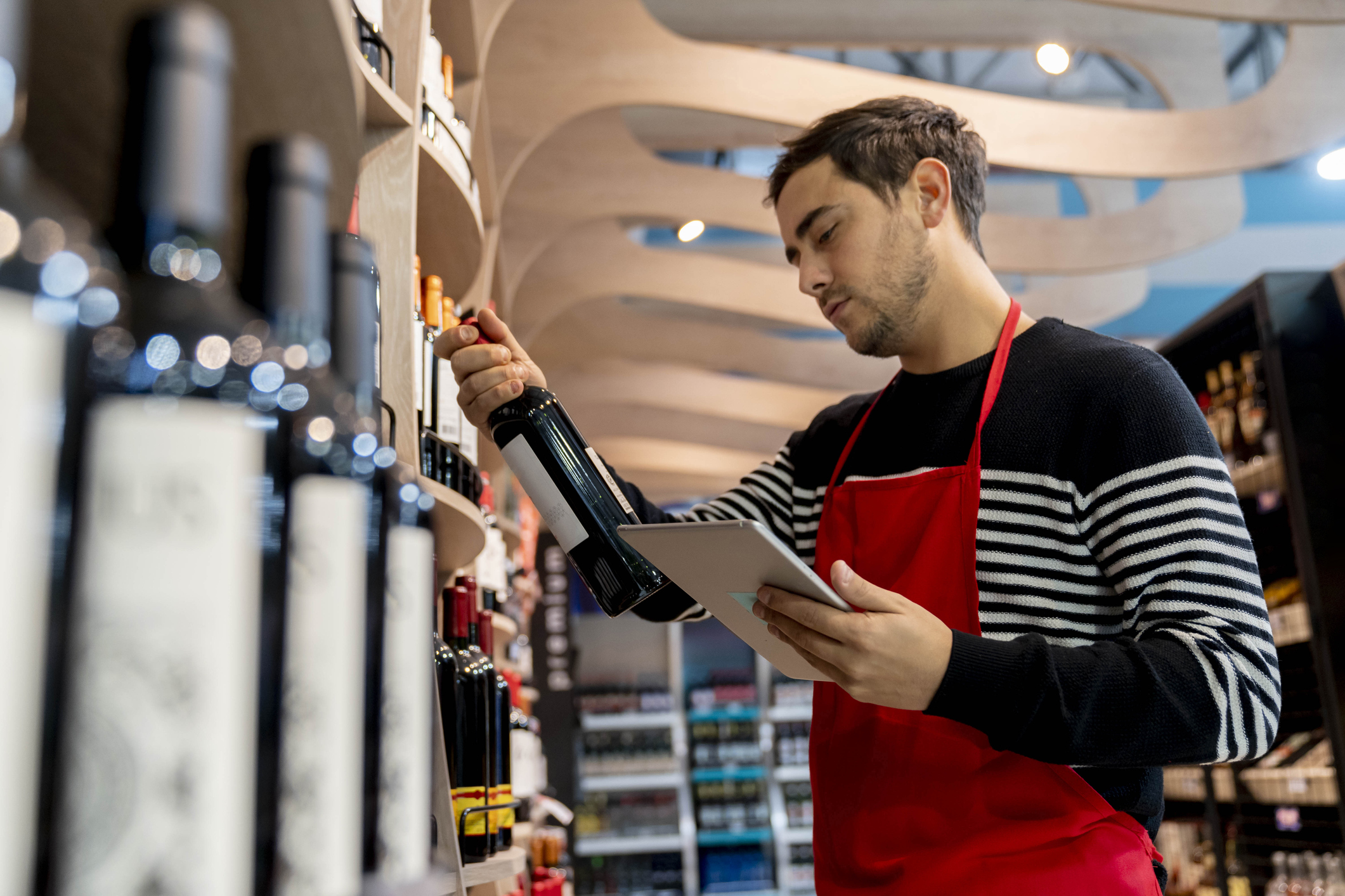 Employee examines a bottle of wine